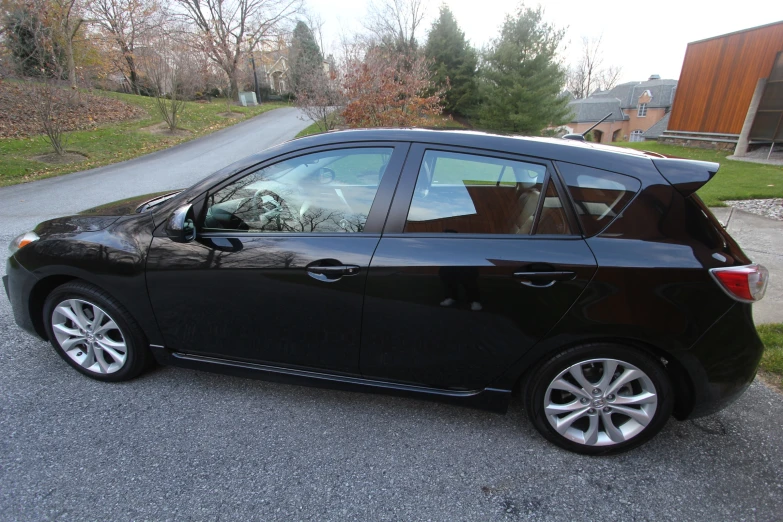 a black car is parked by the side of the road