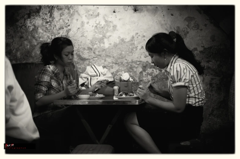 two women sitting at a table sharing a meal