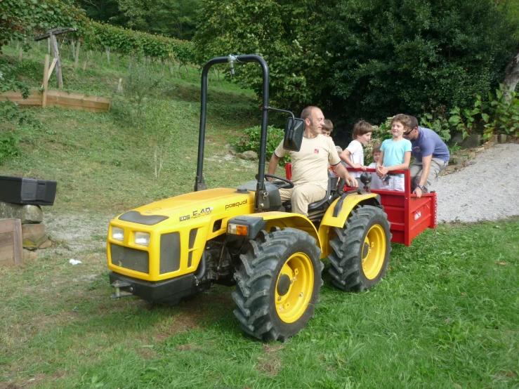 three adults and one child on a small tractor