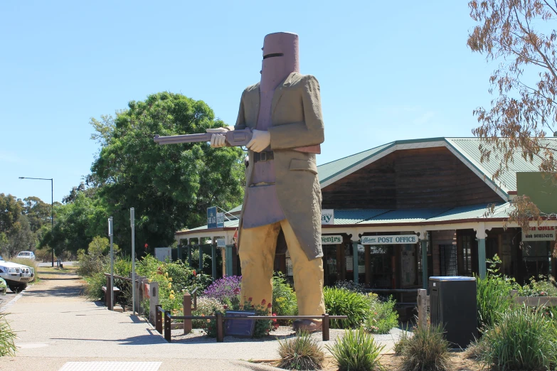 a statue standing in the middle of a path next to some buildings