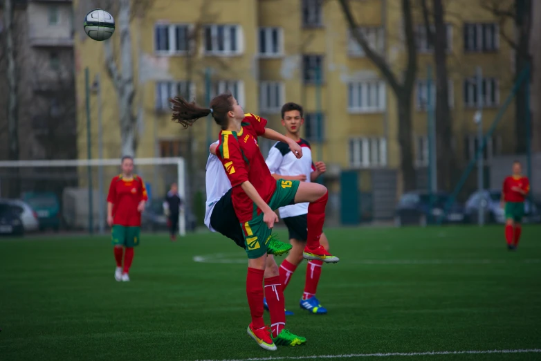 two women playing soccer in front of an apartment building