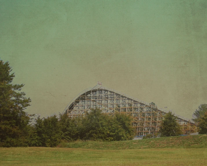 an abandoned roller coaster sits abandoned in the middle of trees