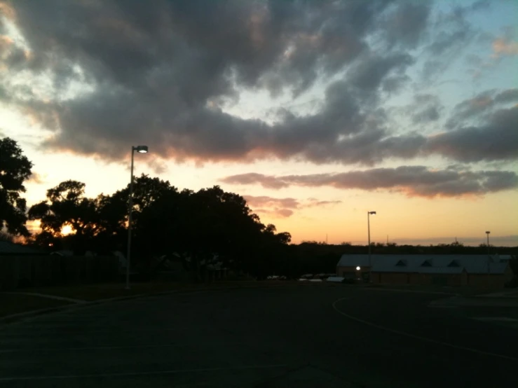 the sun is setting over a parking lot