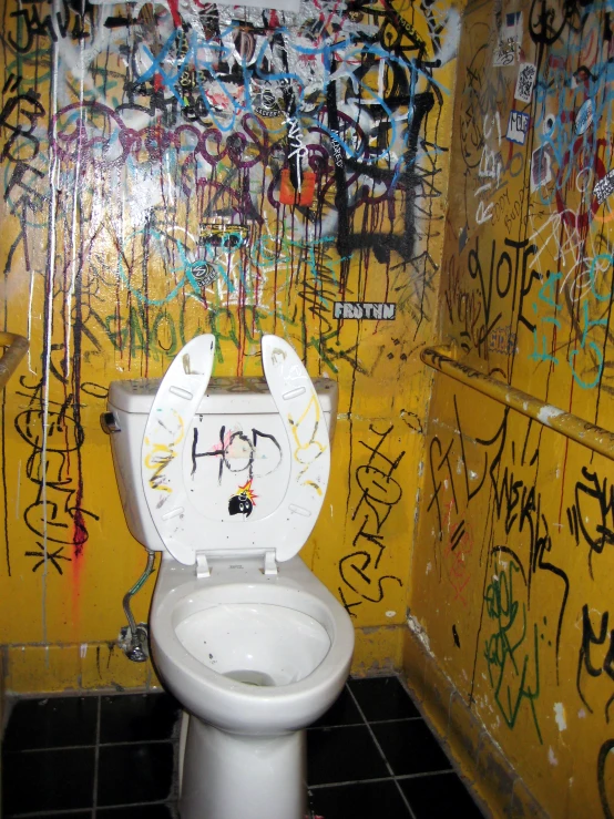 a toilet has been decorated with lots of colorful graffiti