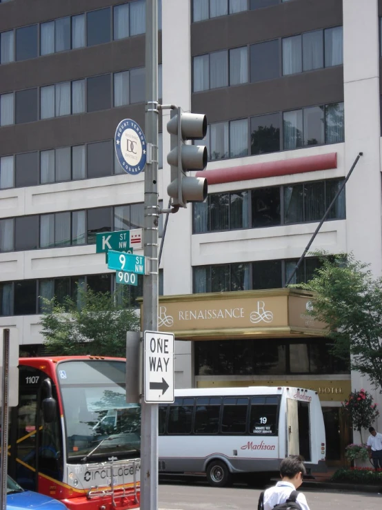 bus waiting at the stop light while pedestrians cross