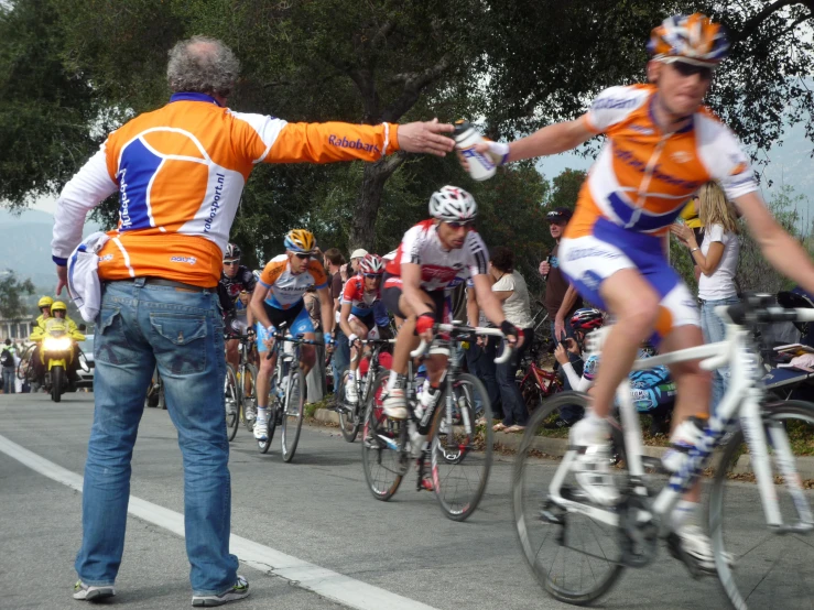 the cyclist is giving another cyclist a high five