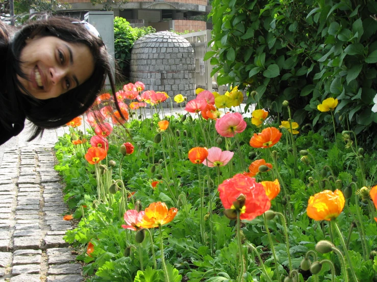 woman with flowers in foreground and green trees behind