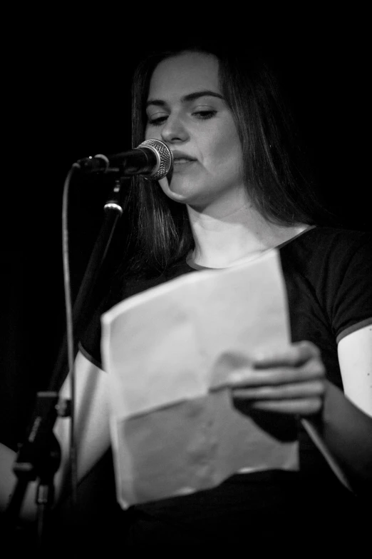 a woman with glasses is reading a paper