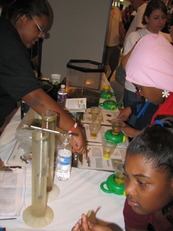 several people sit around a table while making desserts