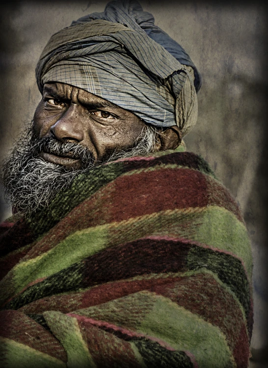 an old man with a big turban looks to the right