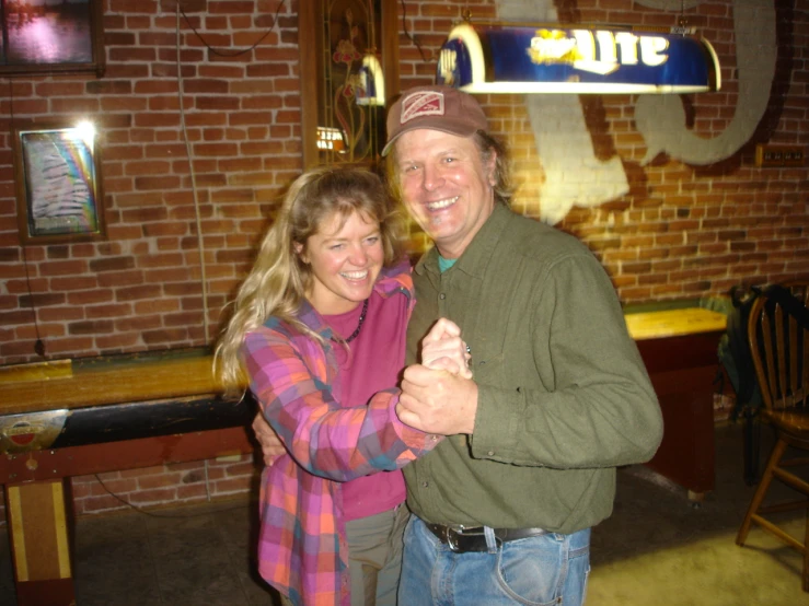 the man and woman are dancing in front of the bar