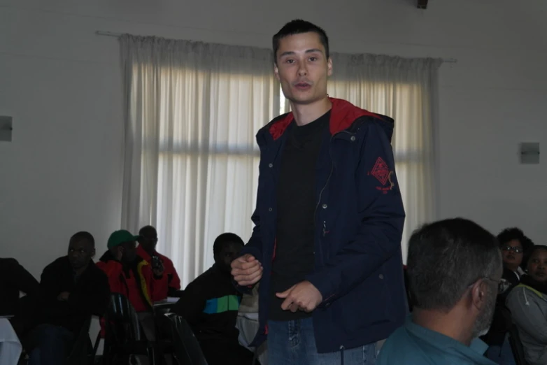 a young man standing in front of a group of people