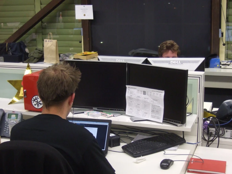 the man looks on from behind the computer monitor