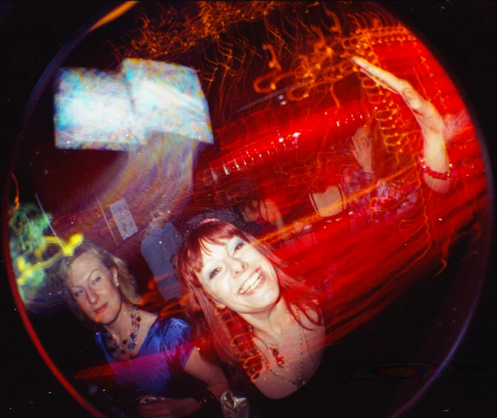 two women are standing at a party