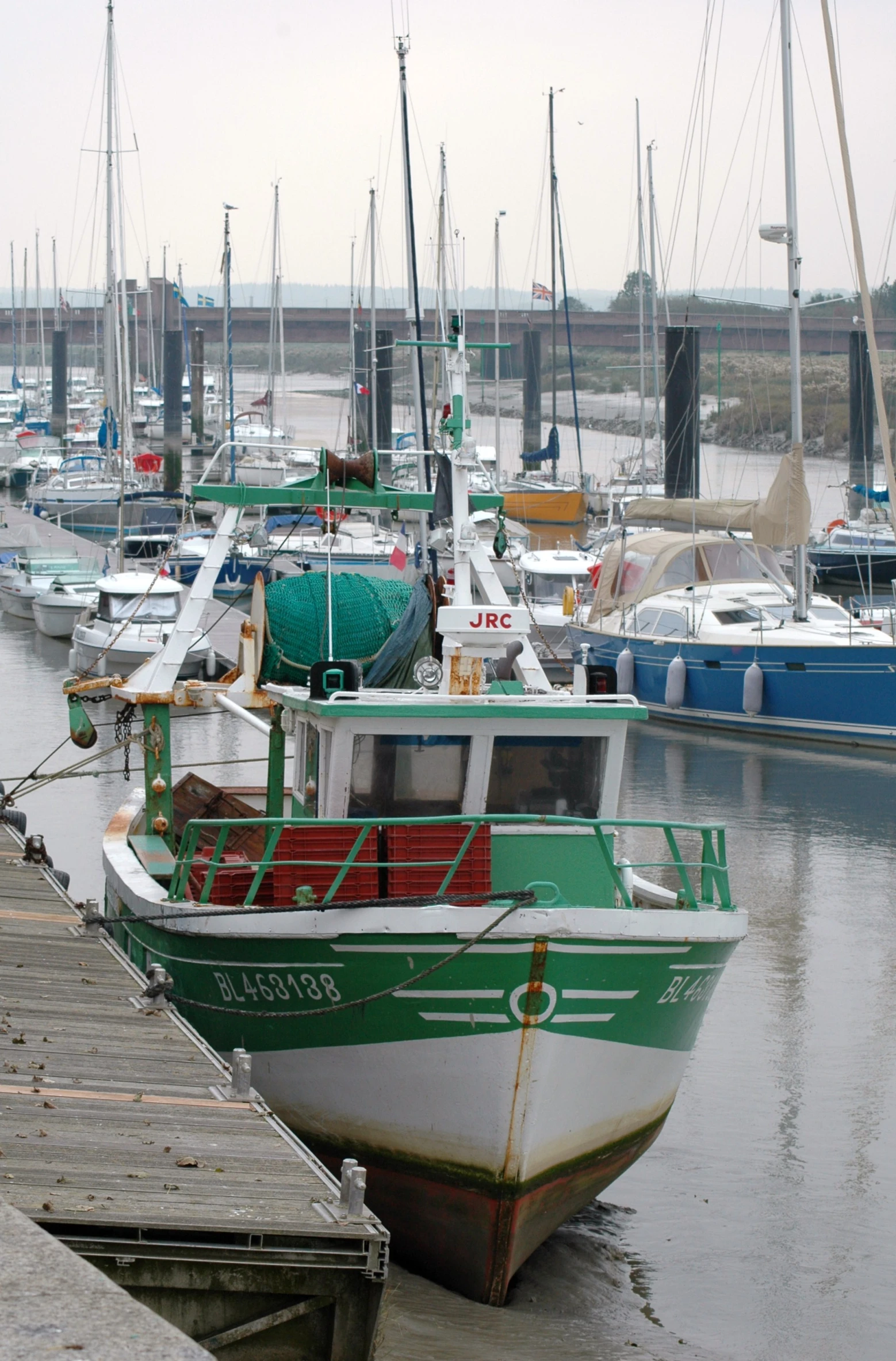 a boat docked at a dock with boats all around it