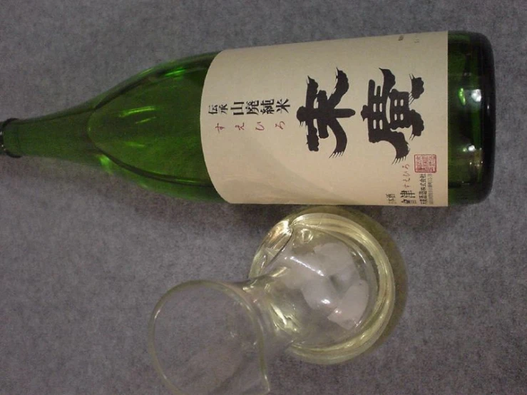 an empty wine bottle with a wine glass beside it