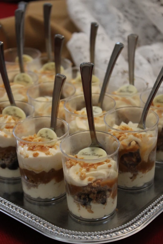 desserts are displayed in small cups, on a plate