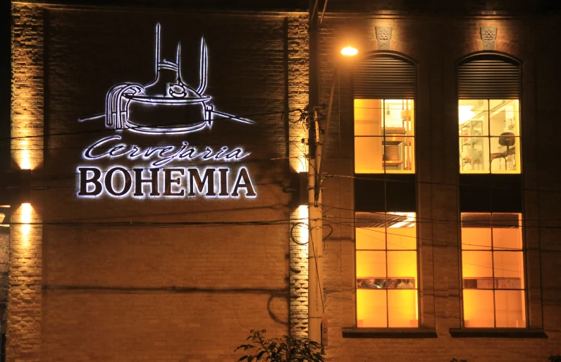 a brick building with a white light at the top and lit up window