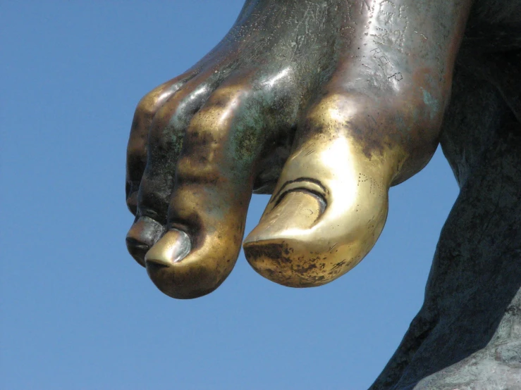 the foot of a bronze statue is pointed towards soing