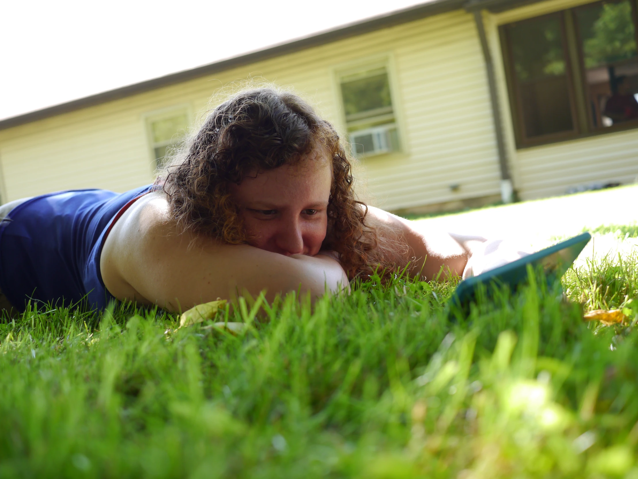 the girl is laying on her stomach in the grass