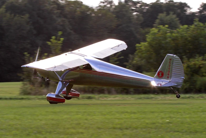 an airplane with a single propeller sitting in the grass