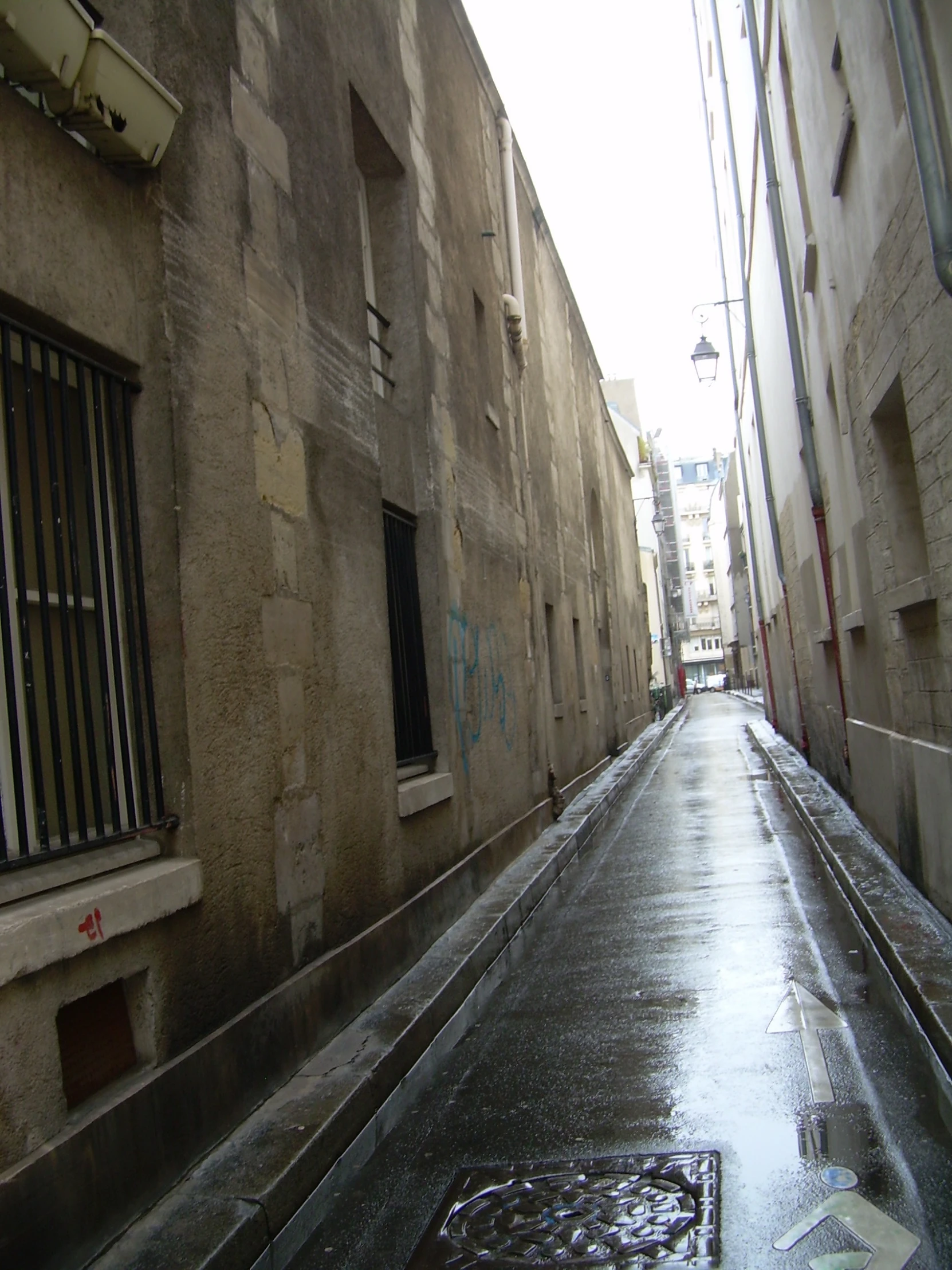 a wet city street with a rain covered sidewalk