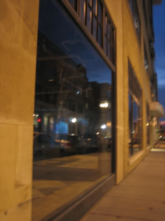 an empty city street with a traffic light reflected in the window