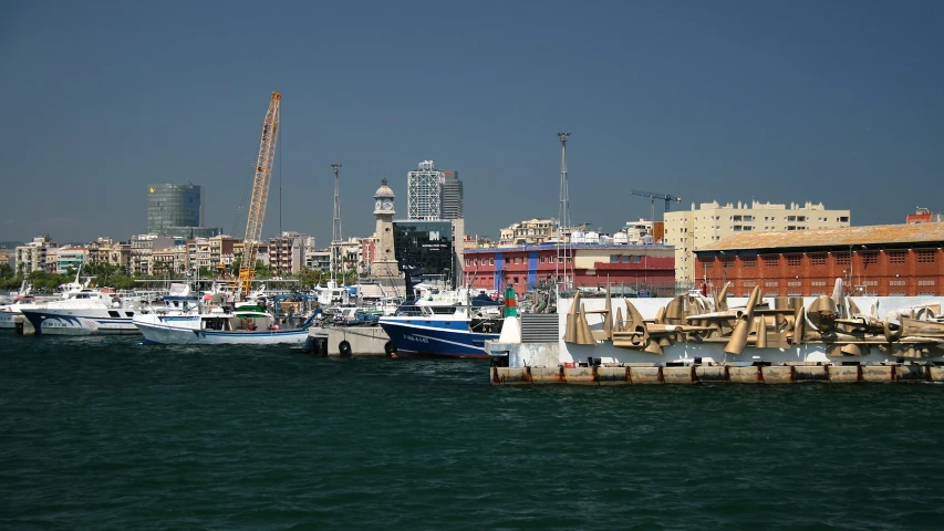 several boats are docked in the water beside a city