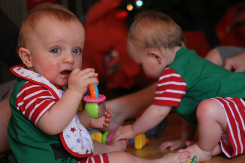 there are two baby boys sitting next to each other