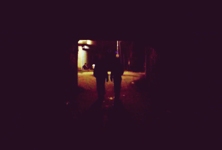 two people standing in the dark near each other