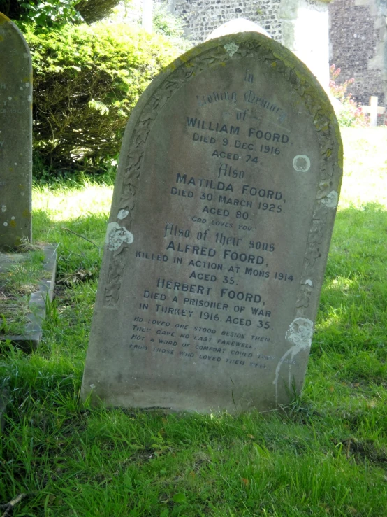 the headstone on a headstones stone stands in a field with green grass