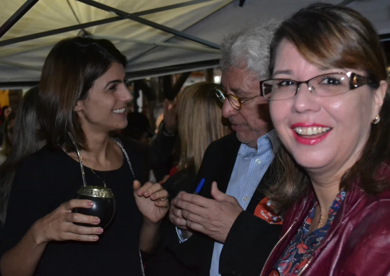 two women and a man with drinks talking