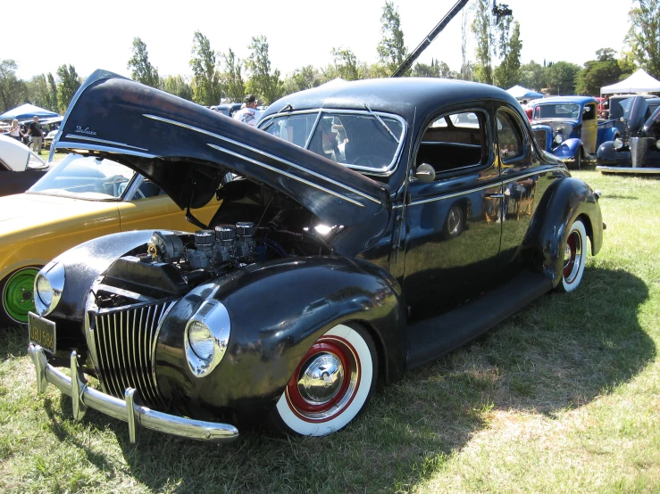 vintage cars parked at a car show with people and trucks