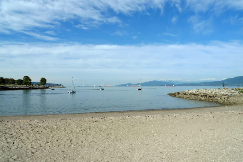 a beach filled with boats under blue skies