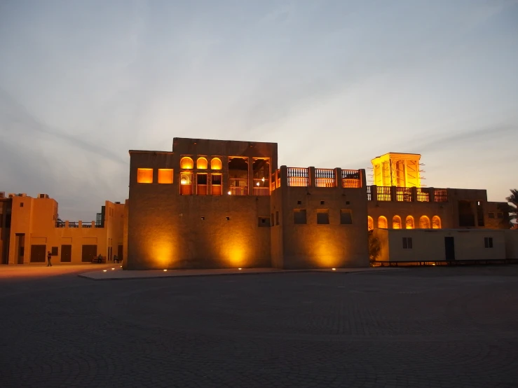 several stone buildings at night time with lit up windows