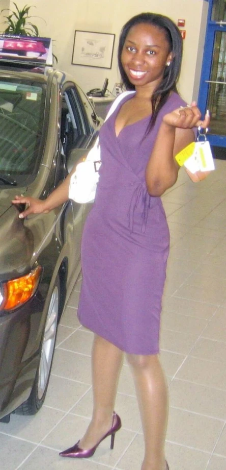 a woman standing in front of a car holding shopping bags