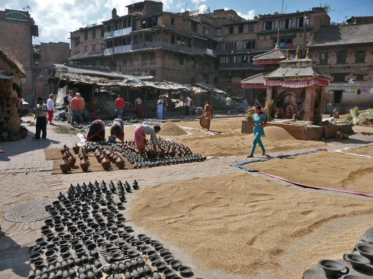 there is a lot of sand on the ground with people looking at it