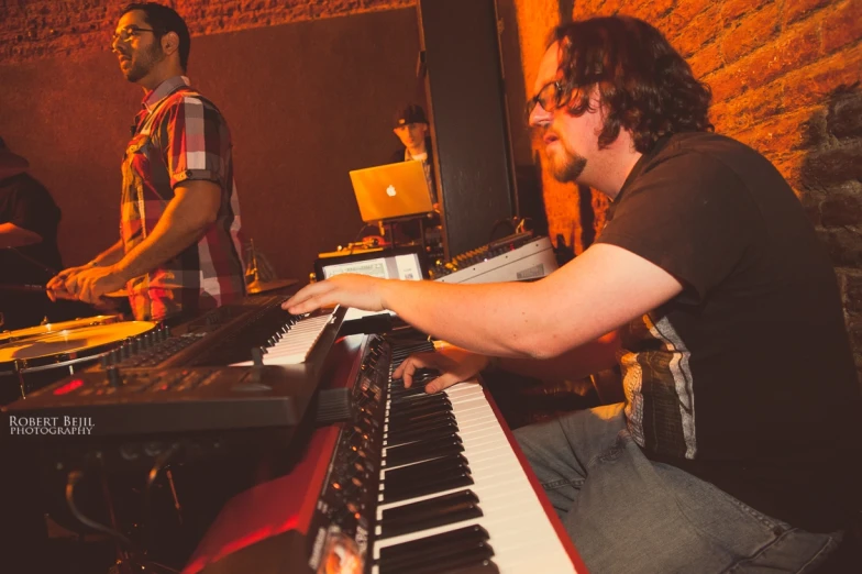 a man sitting at a keyboard with a keyboard next to him