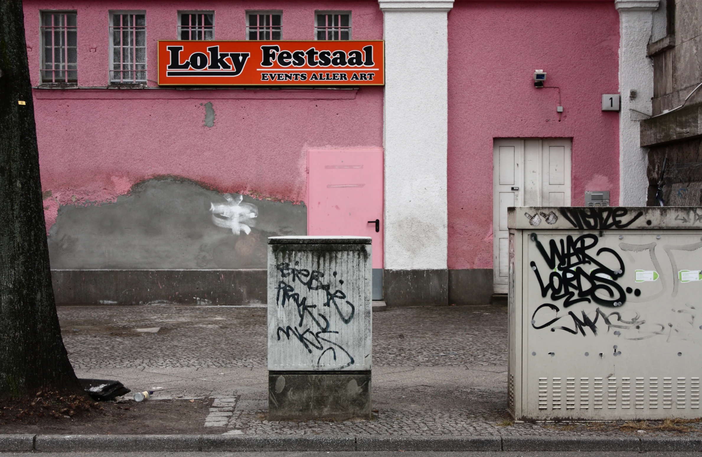 the trash can has been tagged and the building is pink