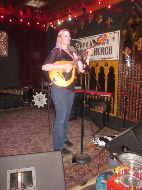 the woman is playing her guitar on stage