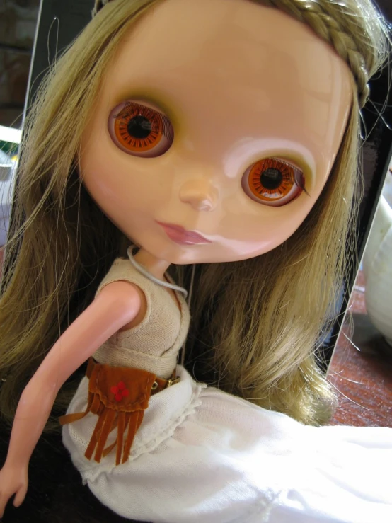 a doll with big eyes that are wearing a white dress