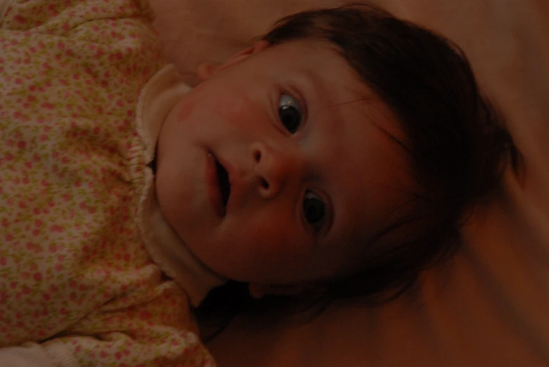 a close up of a baby laying on top of a blanket