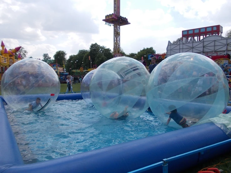 three people in the water inside of large floats