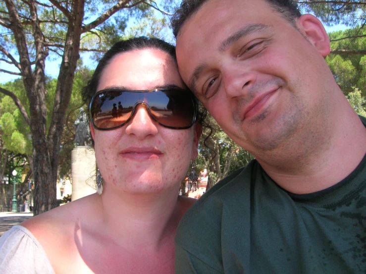 a man and a woman wearing sunglasses posing for a picture