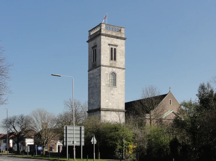 a large clock tower stands next to buildings