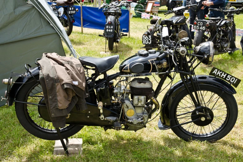 a motor cycle parked in a field next to tents