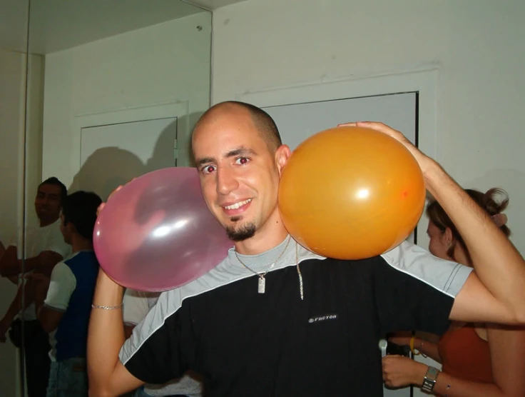 the young man is holding balloons in front of his face