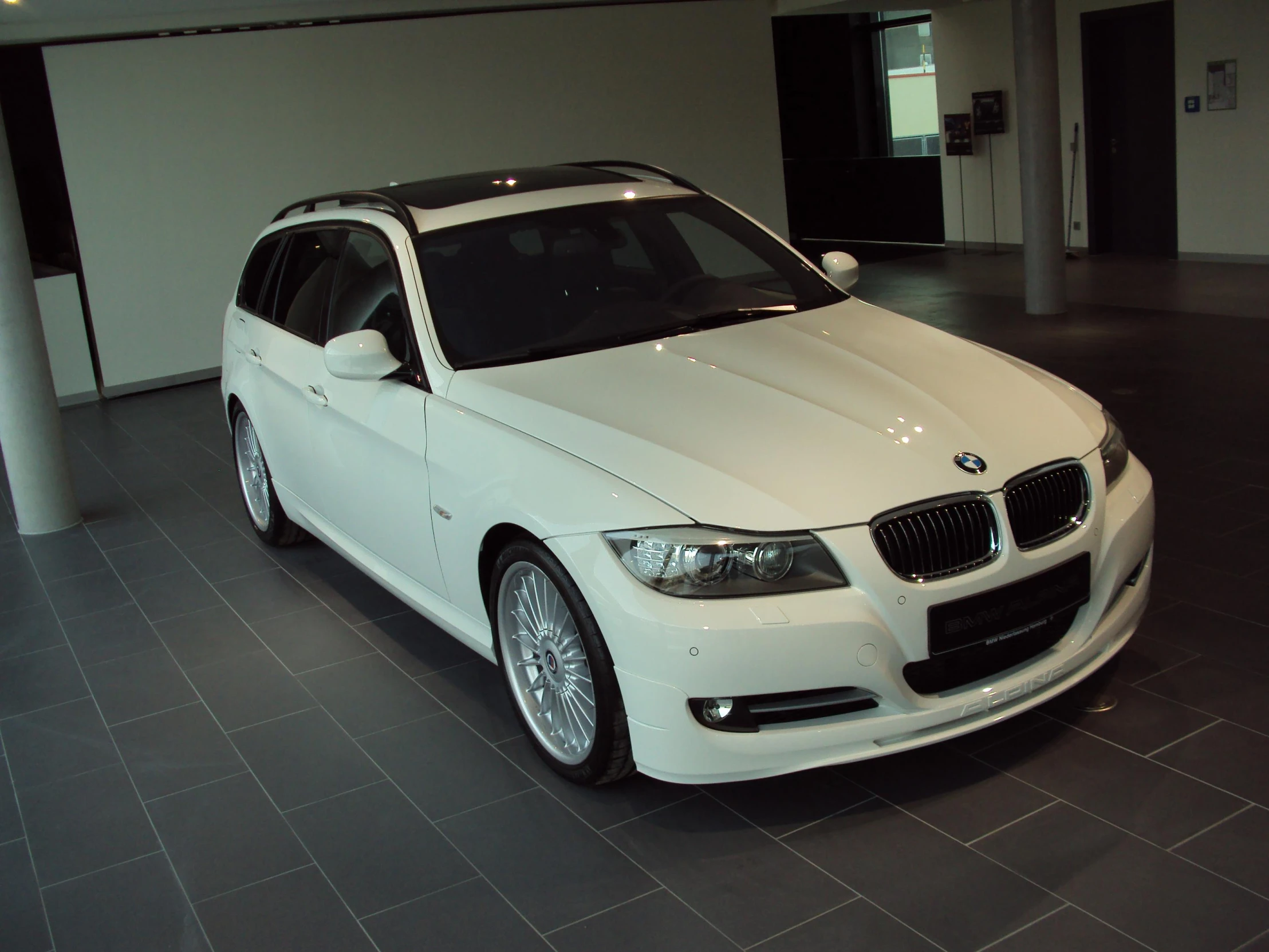 a white bmw parked in a room on display