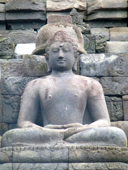 an intricate statue is sitting next to an old wall