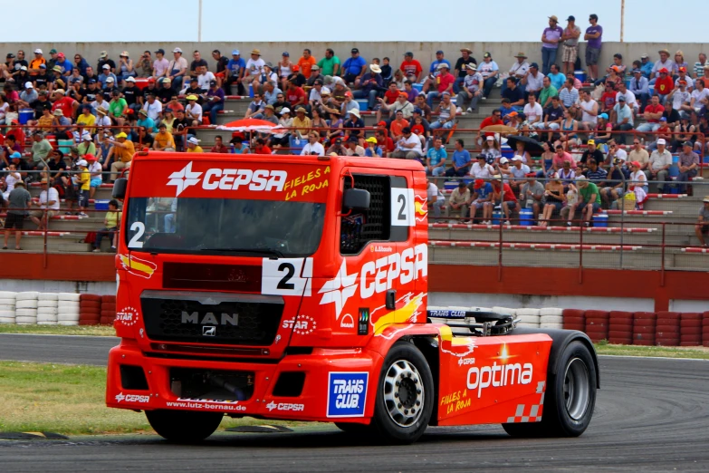 a truck is going around the track in front of an audience